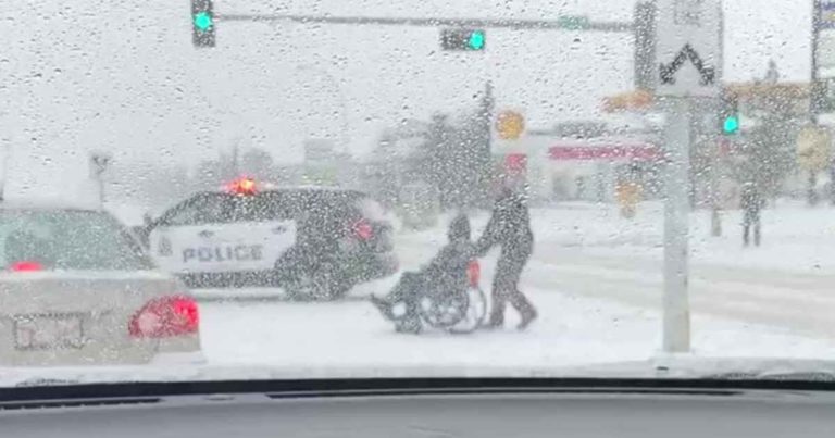officer-helps-man-in-wheelchair-cross-street