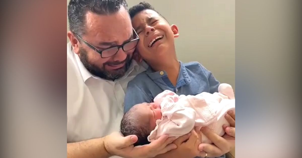 dad and son crying holding baby