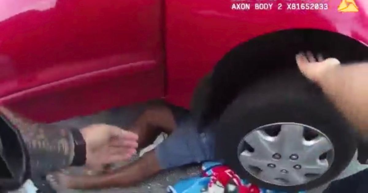 officers rescues man trapped under car