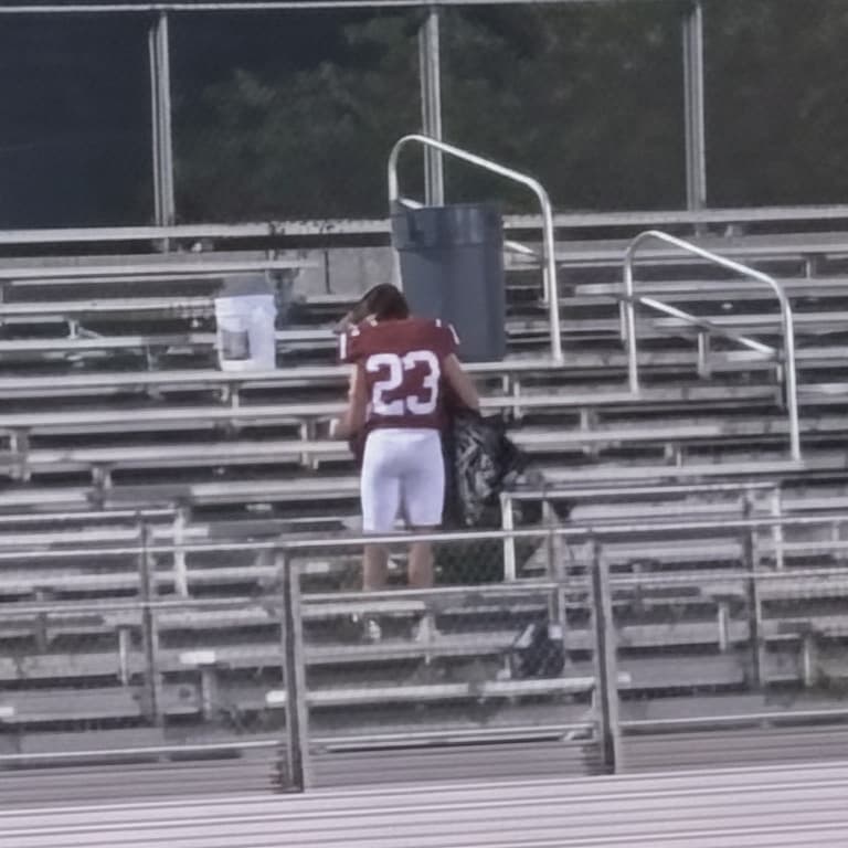 football player helping janitor